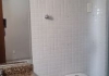 Banheiros com bancada em granito e revestimento nas paredes